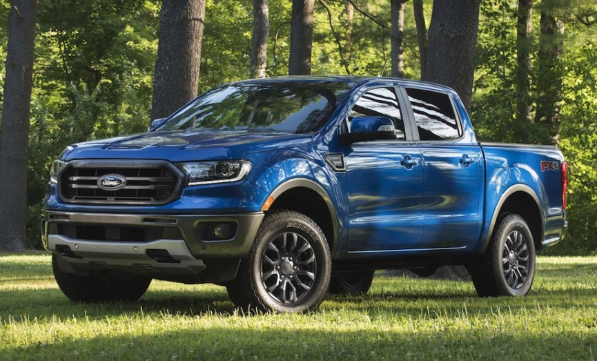 Blue Ford Ranger parked on grass in a field on a summer morning