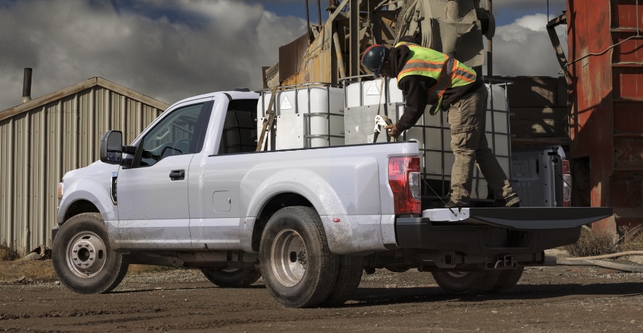 White Ford Super Duty on a construction site with white water tanks in the truck bed