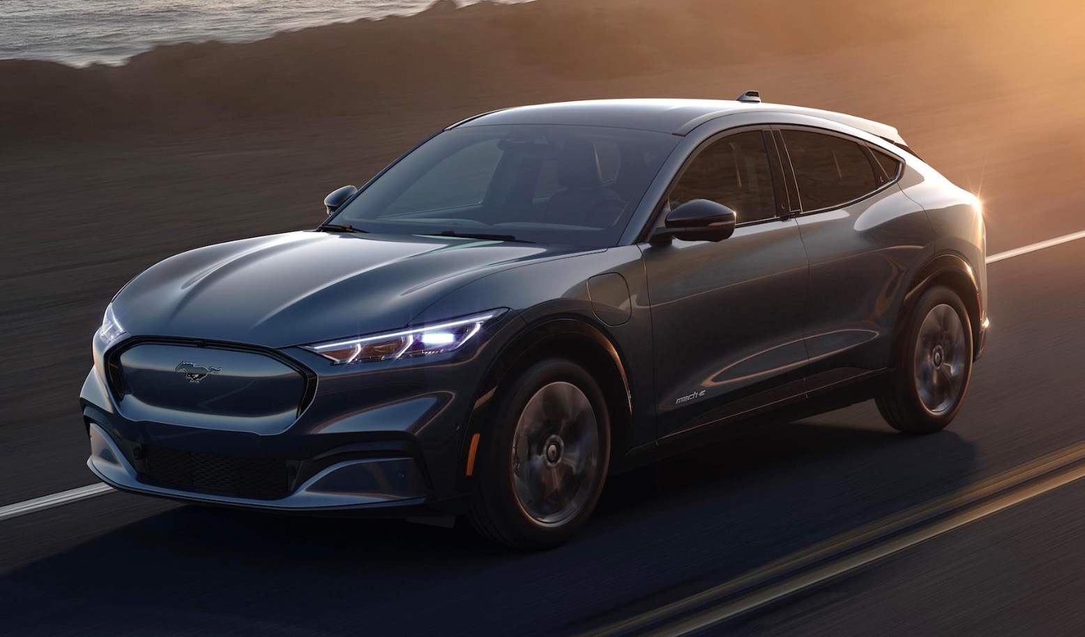 Mustang Mach-E driving along the ocean at dusk