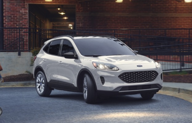 Ford Escape in white parked in front of a brick building